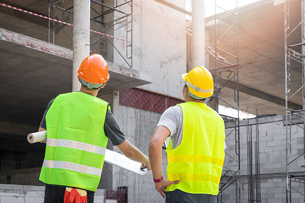 Confident team of architect working together in building construction site. They discussing about new startup project. Architect discuss with engineer about project . Architectural concept.