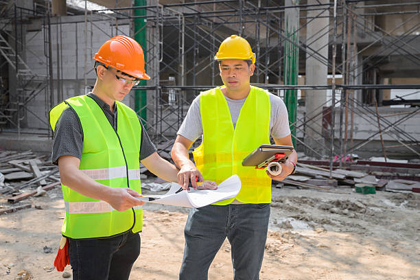 Confident team of architect working together in building construction site. They discussing about new startup project. Architect discuss with engineer about project . Architectural concept.