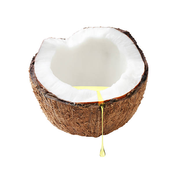 Coconut with dripping oil isolated on white
