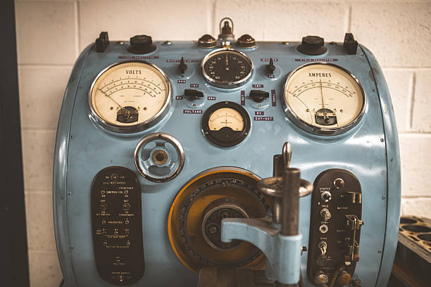 Close-up of a retro blue testing machine featuring multiple analog meters, dials, and toggle switches for electrical diagnostics