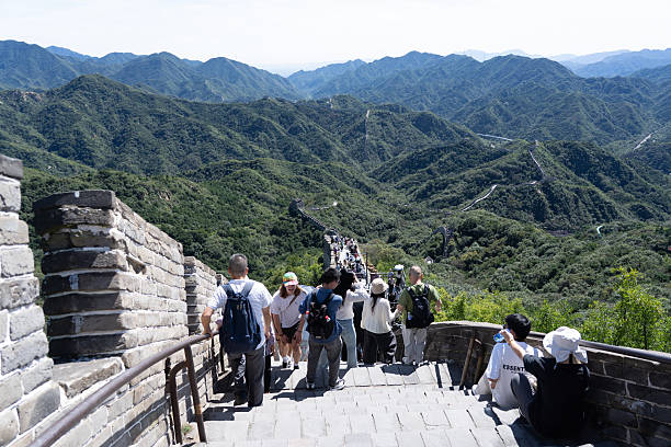 Sep 18 2025 - Beijing, China: Tourists on the Great Wall of China, showcasing the wall's massive stone structure and scenic mountain backdrop.