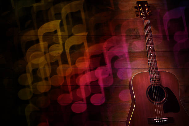 Acoustic guitar on a wooden planks background with musical note shaped bokeh. It's a REAL bokeh photo, not a computer effect.