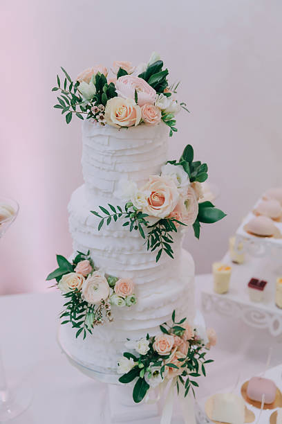 A three tier wedding cake with pink and white flowers on it