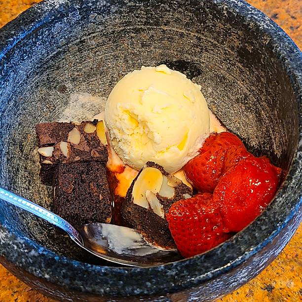 Delicious Chocolate Brownie with Vanilla Ice Cream Scoop and Fresh Strawberries Served in Rustic Stone Bowl Sweet Dessert Gourmet Culinary Concept