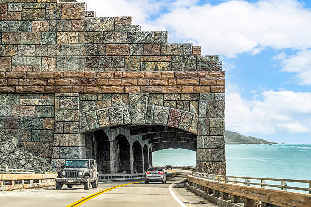 Big Sur, California, United States - February 23 2019: Vehicles driving through the Rain Rocks Rock Shed on Highway 1 in Big Sur, California