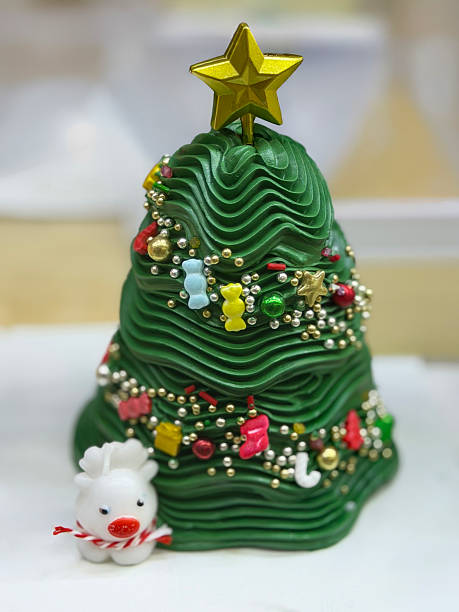 Image of delightful christmas tree cake, green buttercream icing, surrounded by festive presents, gifts, colorful holiday decorations