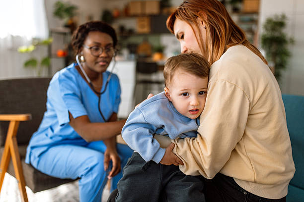 Black Female Pediatrician at Home Visit Doing a Health examination for a Cheerful Young Boy, using Stethoscope