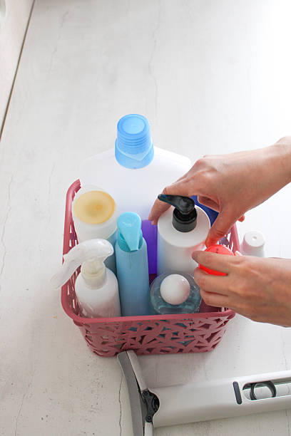 Top view of a hand holding a white plastic bottle with a pump dispenser and placing it into a basket with other empty containers. The image represents recycling, waste sorting, and responsible plastic disposal. It highlights environmental awareness, sustainability, and eco-friendly household practices.