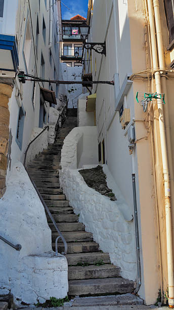 Steep, winding stone stairs ascending a narrow alley in an old european town