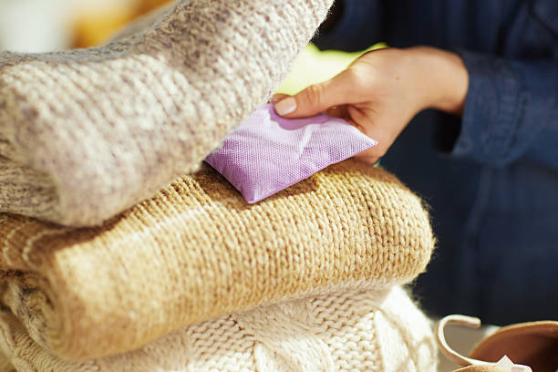 Detail of Hands Placing Lavender Sachet in Knitted Sweaters