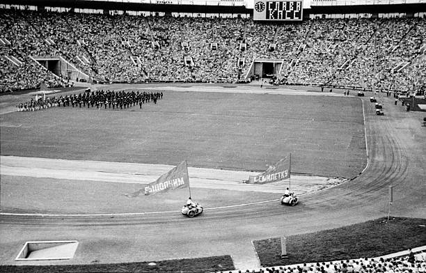 Moscow, Russia, - June 25, 1961: motorcyclists with flags with slogan Let's complete seven year plan at parade in honor of Soviet Youth Day at Central Lenin Stadium