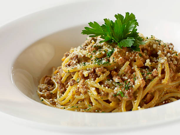 Spaghetti pasta with meat sauce and parmesan cheese on white bowl
