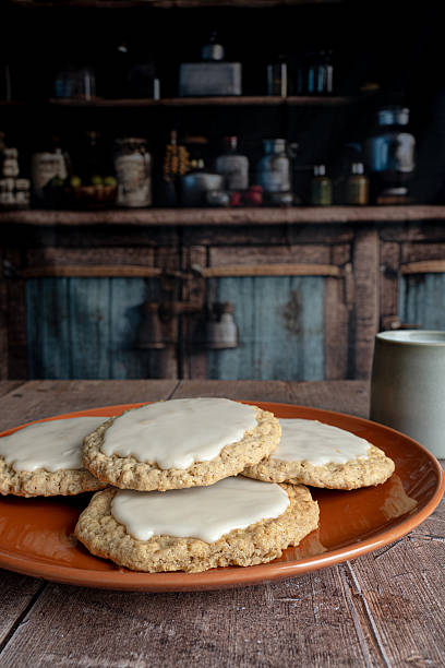 Stack of Iced Homemade Oat Biscuits with Ceramic Mug on Wooden