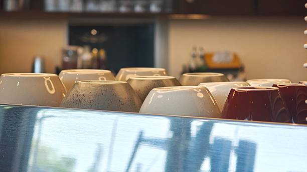 Stack of coffee cups on coffee maker.