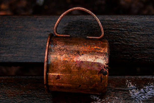 Rusty Metal Cup On Wet Wood, Closeup Showing Copper Patina And Water Droplet, Moody Lowkey Lighting