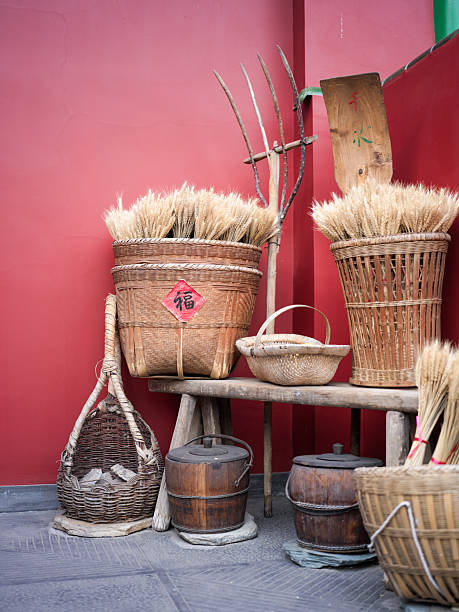 Traditional Farm Tools and Wheat Baskets Under Red Walls