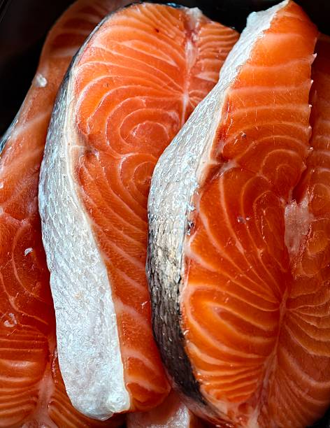 Several fresh, raw salmon steaks