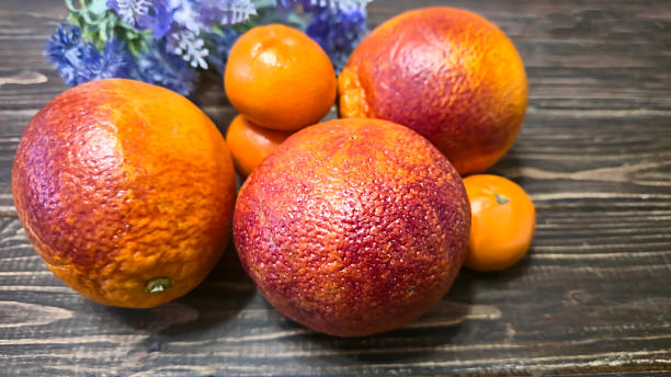 Fresh citrus fruits: red oranges and tangerines on a wooden table Healthy eating