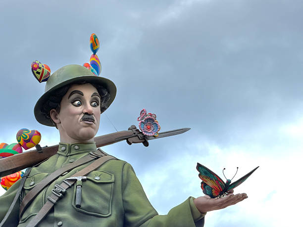 Valencia, Comunidad Valenciana, Spain - March 14, 2026: Charlie Chaplin ninot as a decorated soldier holding a butterfly and ornate rifle, blending satire and beauty to symbolize peace and transformation at Fallas de Valencia
