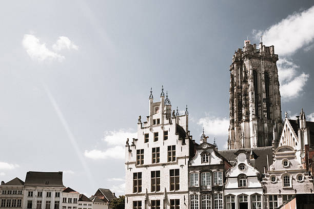 A view on some medieval houses and the St. Rumbold's cathedral in the historic town of Mechelen or Mechlin in the Flanders region of Belgium