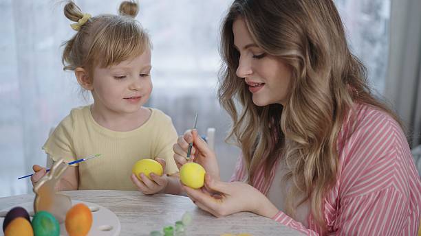Mother and child paint Easter eggs together