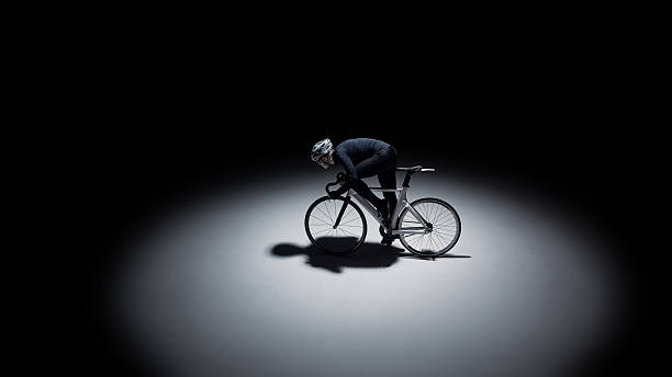 Minimalist cyclist racing in dark studio with large copy space. Concept of advertising banner, sports campaign, performance branding, endurance motivation and clean mockup design.