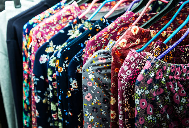 Collection of women's clothes with floral pattern hanging on rack for sale