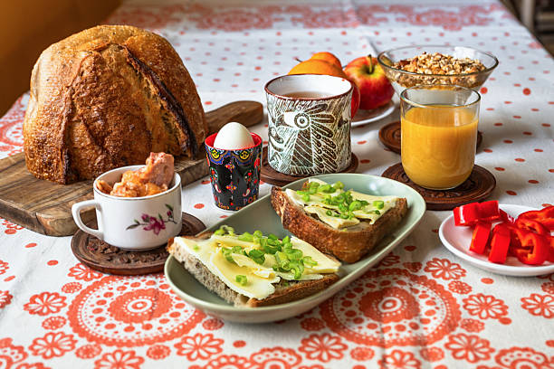 Rich breakfast with bread, beverage,vegetable and fruit, pickled meat, boiled egg and porridge.