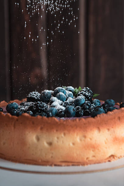 Powdered sugar falling on blueberry cheesecake