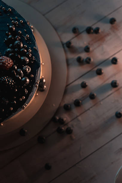 Blue cake with berries on wooden table top view