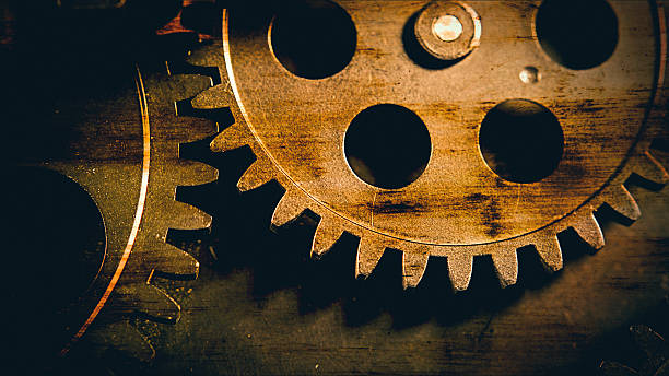 High-quality industrial grunge background featuring rusty, interlocking vintage metal gears and cogs. This gritty steampunk aesthetic symbolizes complex systems, historical machinery, teamwork, and the mechanical foundations of law, justice, and global order