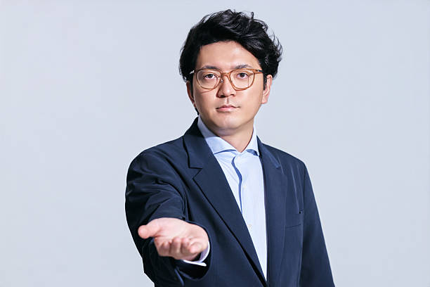 Cool businessman in glasses holding invisible object on white