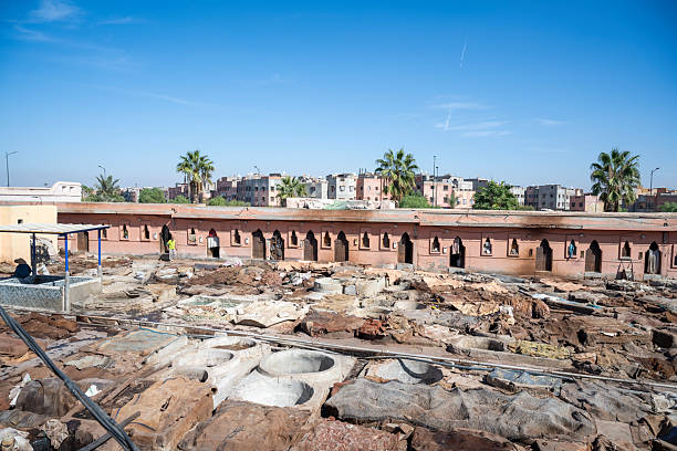 Panoramic view of a traditional leather tannery with circular pits and drying hides in Marrakesh, Morocco.