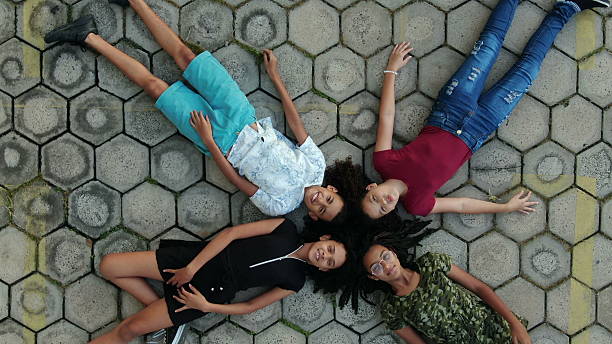 Children seen from above on lying on ground staring at the sky