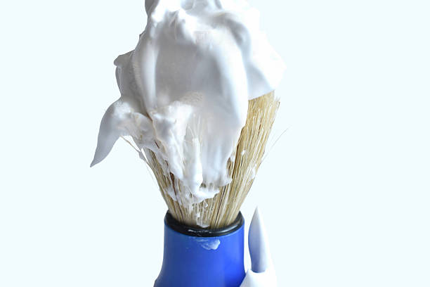 Shaving brush with soap foam isolated on white background.