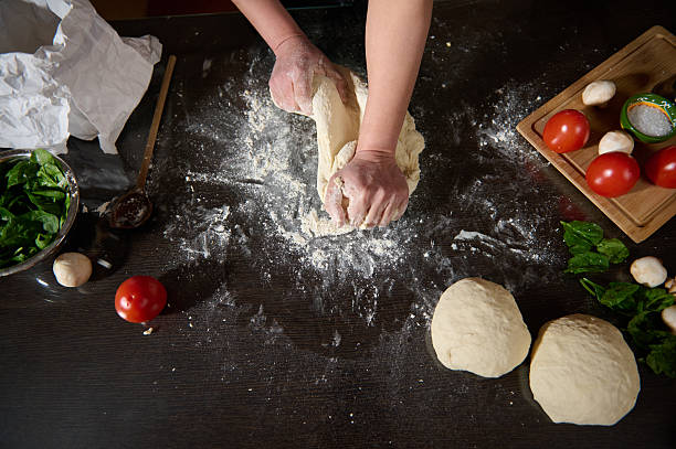 Woman in Black Chef Apron Making Homemade Pizza With Fresh Organic Ingredients