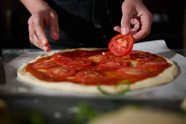 Woman in Black Chef's Apron Making Homemade Pizza With Fresh Organic Ingredients
