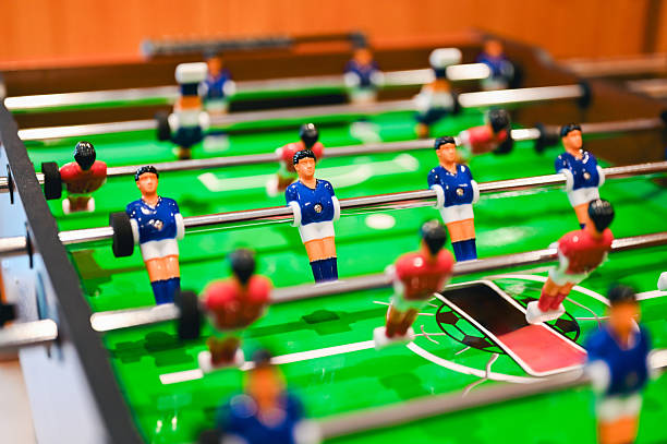 Foosball table showing red and blue teams ready for competition