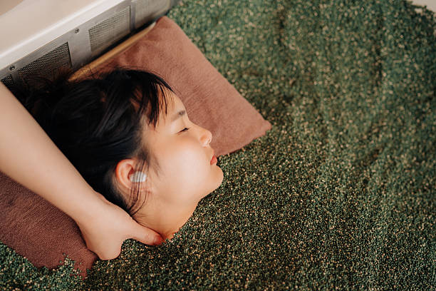 Young Asian woman lying in herbal spa bath for relaxation