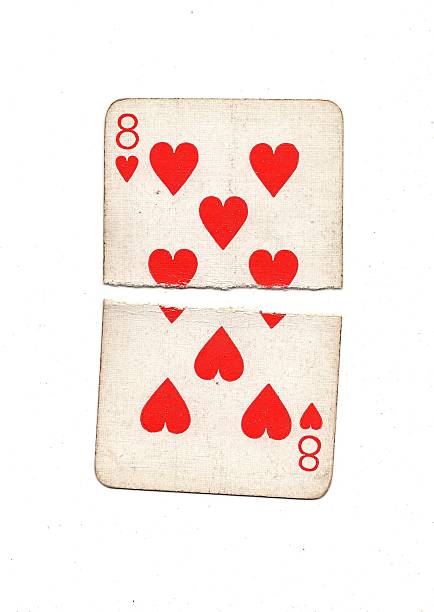A vintage playing card torn in half and isolated on a white background.