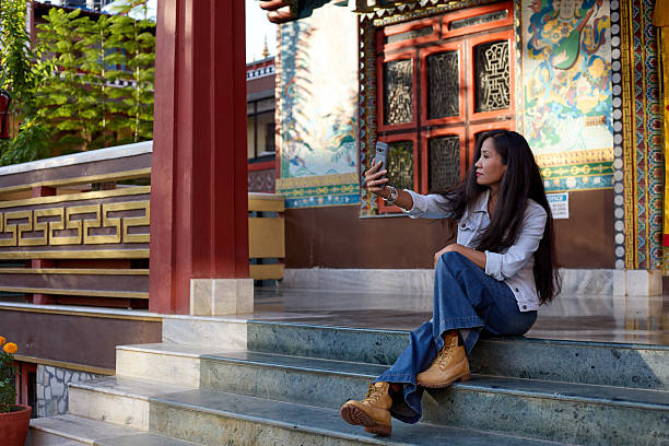 Female traveler sitting and looking at smartphone screen