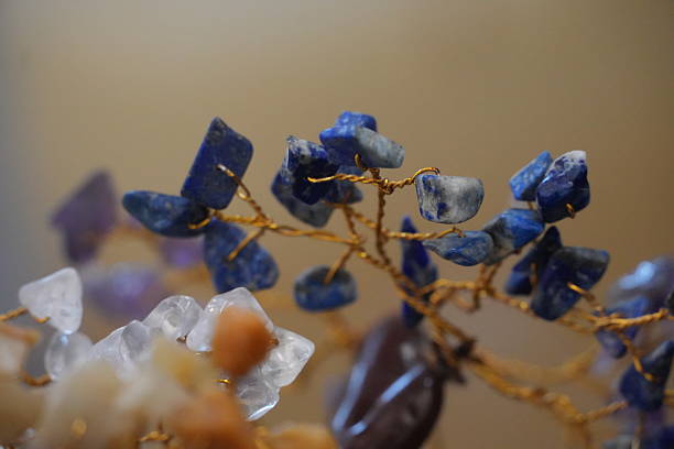 This close-up showcases the intense blue shades of crystal chips meticulously wired onto a decorative tree. It offers a beautiful focal point for any room seeking tranquility and style.