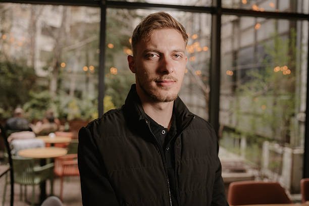 Portrait of confident young man in modern cafe environment
