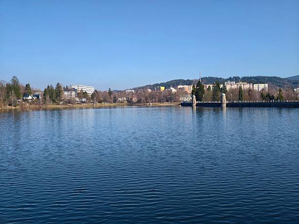 Historic reservoir with twin intake towers standing on pier, calm reflective water, clear sky, architectural