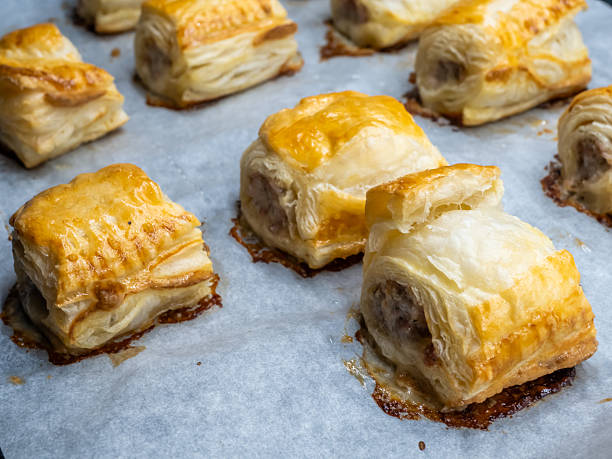 Fresh baked puff pastry rolls on baking tray closeup