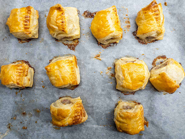 Fresh baked puff pastry rolls on baking tray closeup