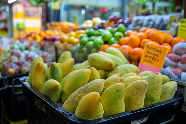 Fresh yellow mangoes on display at a fruit stall.