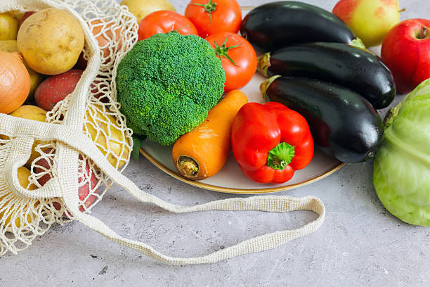 Abundant selection of garden fresh vegetables and ripe fruits displayed on a kitchen counter for healthy cooking