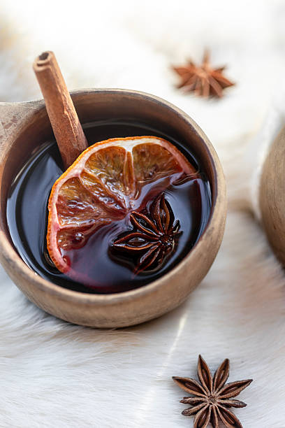 Rustic wooden mugs filled with warm spiced mulled wine