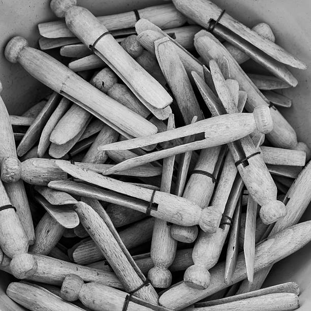A bucket filled with wooden clothespins ready for laundry tasks.